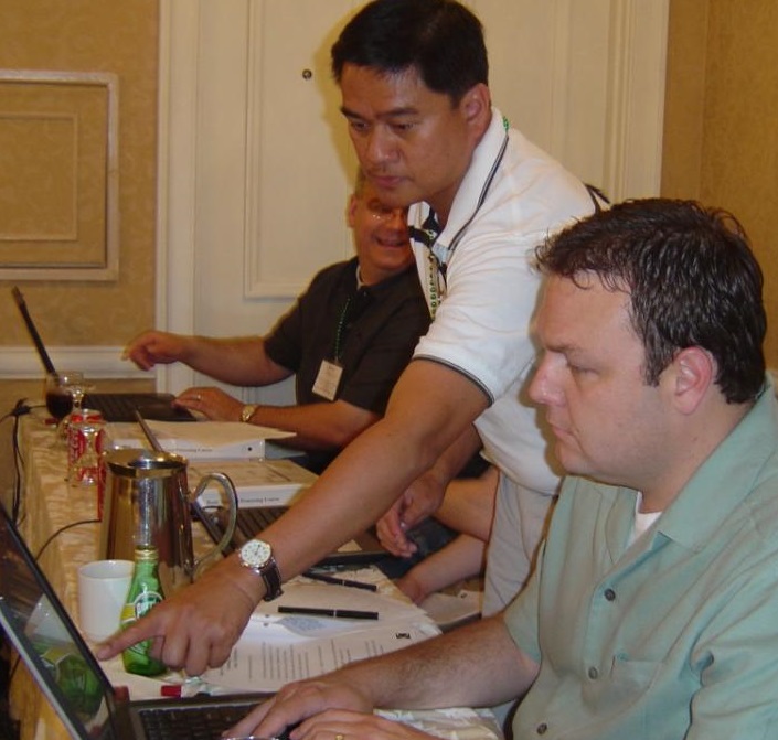 Photo of a man teaching another man how to use software