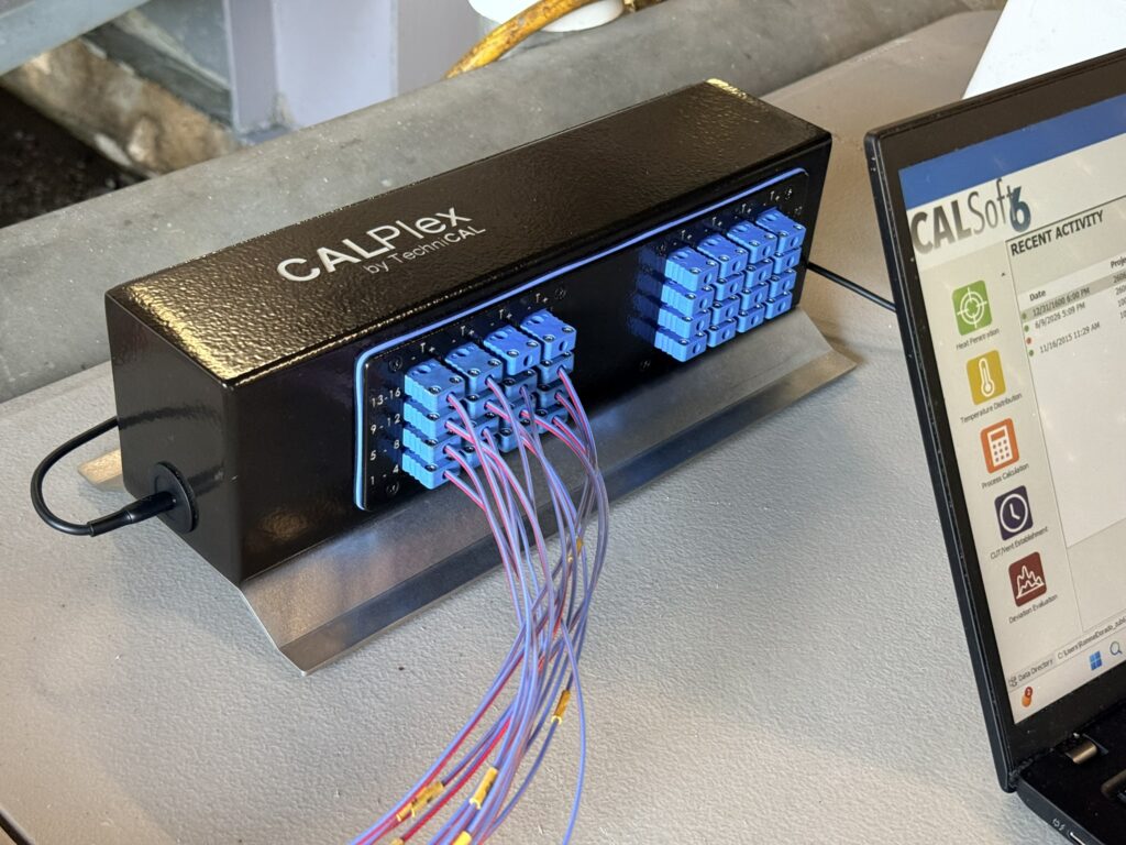 CALPlex unit with wires and part of a laptop screen showing CALSoft 6 software